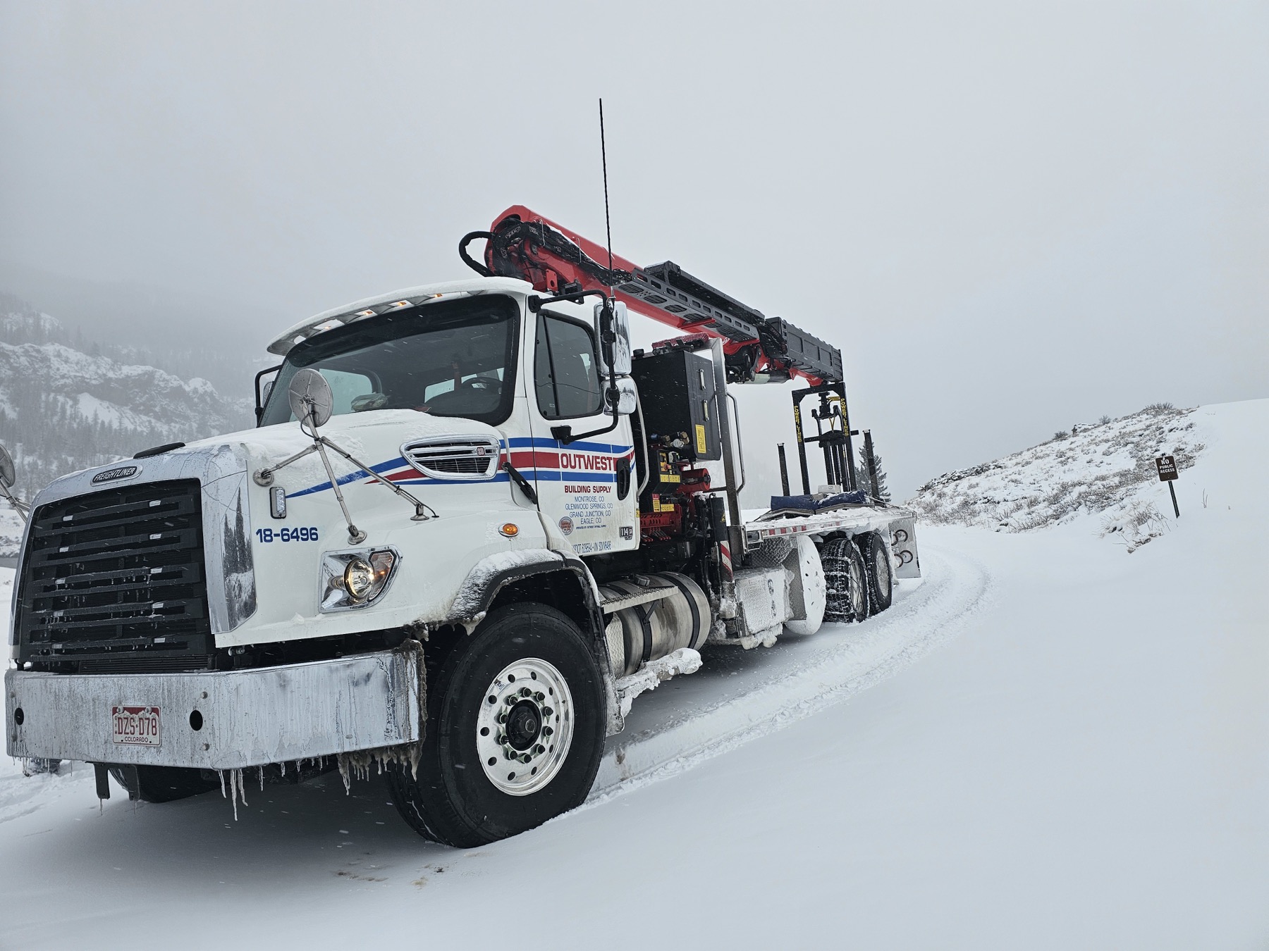Camión grúa de Outwest en una carretera nevada de Colorado